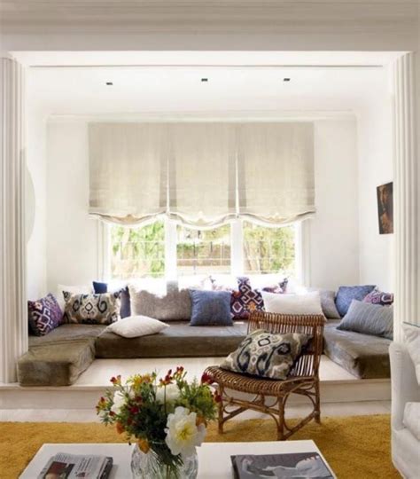 A Living Room Filled With Lots Of Furniture Next To A Window Covered In