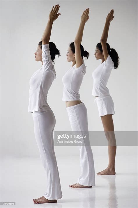 Three Women Standing In Yoga Posture Mountain Arms Overhead In Prayer