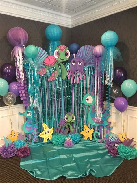 An Under The Sea Themed Birthday Party With Balloons Streamers And Decorations On Display
