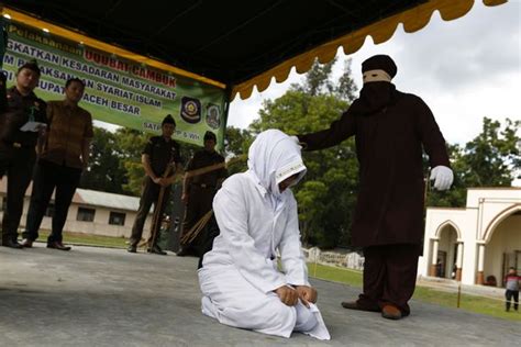 Shocking Moment Indonesian Woman Is Whipped By Masked Sharia Law Enforcer For Committing