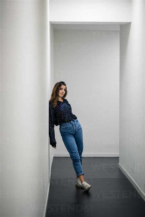 Portrait Of Woman Leaning Against Wall In Corridor Stock Photo