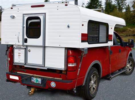 A Red And White Truck With A Camper Attached To Its Back End