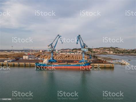 Aerial View Of Cargo Ship Unloading At The Timber Port Stock Photo