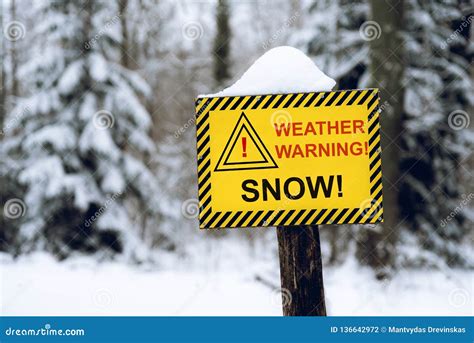 Yellow Weather Warning Snow Sign In The Out Of Focus Forest Background