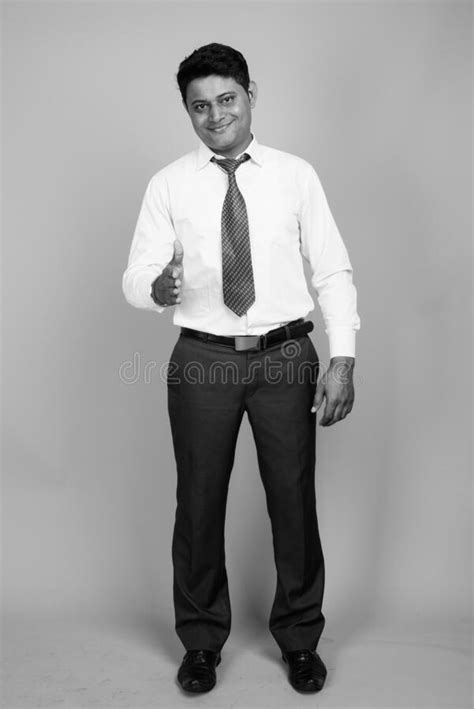 Portrait Of Young Indian Businessman Against Gray Background Stock