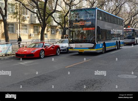 An Electric Double Deck Bus Passes A Ferrari On A Street In Eastern
