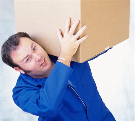 Man Lifting A Large Box Over His Shoulder Spyder Moving And Storage