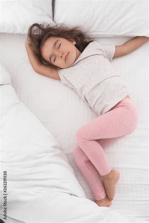 Cute Little Girl Sleeping On Cozy Bed View From Above Stock Photo