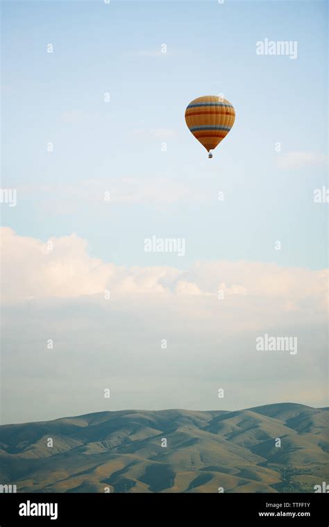 Hot Air Balloon Flying Over The Hills Stock Photo Alamy