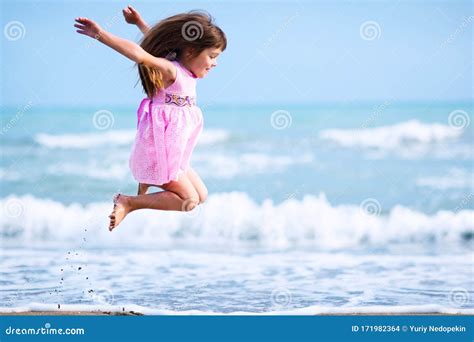 Girl With Brown Hair Jumping On Seashore Stock Photo Image Of Blue
