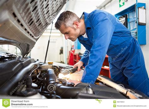 Mechanic Examining Under Hood Of Car With Torch Stock Photo Image Of