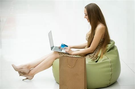 Young Girl Sitting On A Bean Bag With A Laptop Free Photo