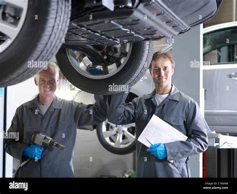 Mechanics Working Under Car Stock Photo Alamy