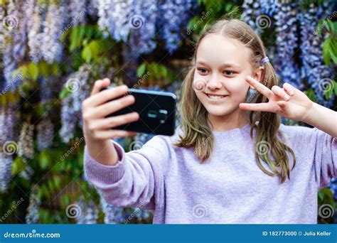 Portrait Of Cute Preteen Caucasian Girl With Ponytails Taking Selfie