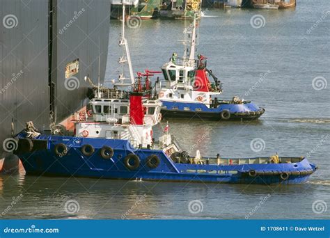 Tug Boats Pushing A Cargo Ship To Port Stock Image Image Of Boat