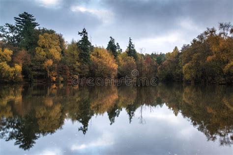 Beautiful Vibrant Autumn Woodland Reflecions In Calm Lake Waters Stock