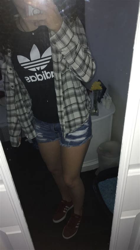 A Woman Taking A Selfie In The Mirror Wearing Shorts And A T Shirt