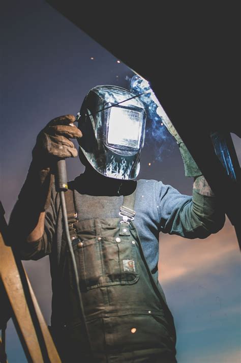 Person In Helmet Welding On Steel Photo Free Asphalt Image On Unsplash