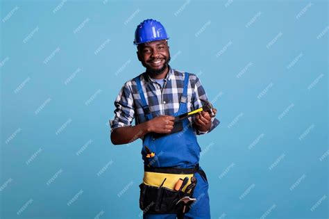 premium photo happy construction worker smiling optimistic against blue isolated background