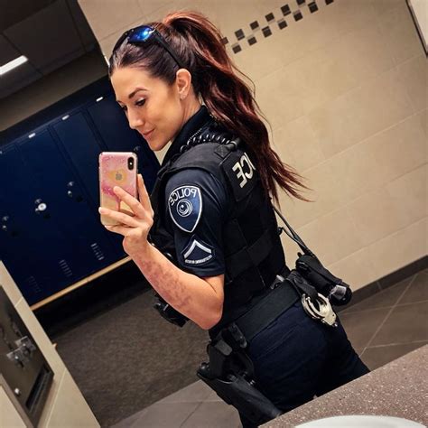 A Female Police Officer Taking A Selfie In The Mirror With Her Cell