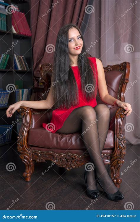 Jovem Mulher Que Senta Se Em Uma Cadeira De Couro Imagem De Stock Imagem De Elegante Luxo