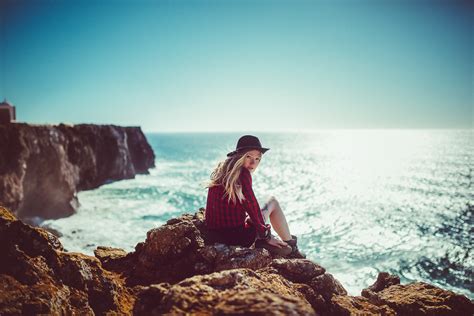 デスクトップ壁紙 女性 モデル ブロンド ビューアを見て 風景 自然 海 崖 岩 晴天 座っている Women With Hats 1500x1000
