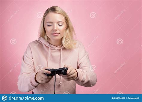 A Gamer Who Is Passionate About The Process A Cute Blonde Is Holding A