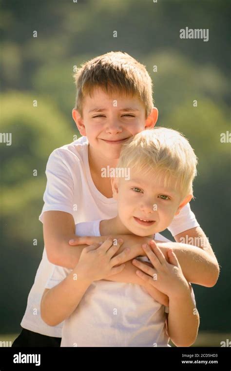 Two Little Boys Are Hugging Outdoors Concept Of Friendship And