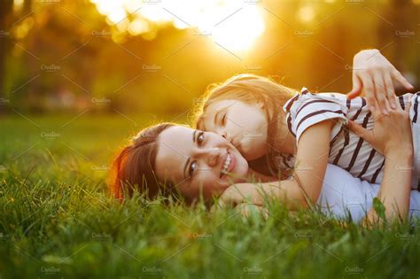 mother and daughter lying on grass high quality people images ~ creative market