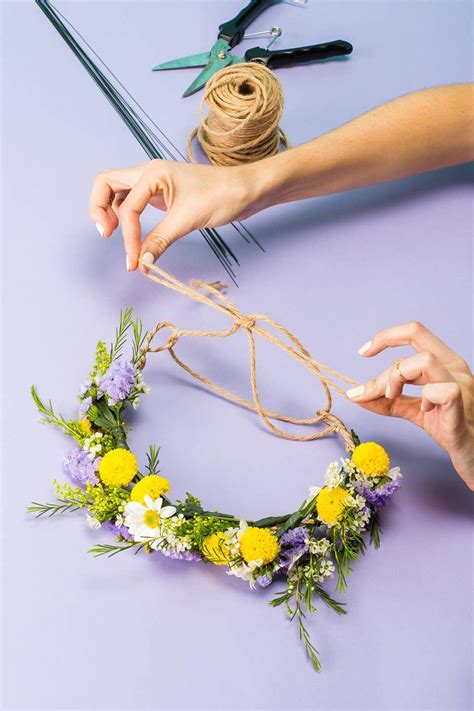 Two Hands Are Making A Flower Crown Out Of Twine And Flowers On The Table