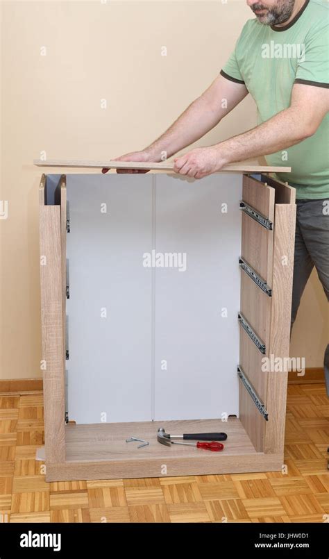 Man Assembling Parts Of New Dresser With Drawer Rails Stock Photo Alamy