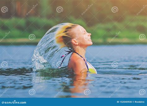 Active Young Blonde Woman Waving Hair Splashing Water In River