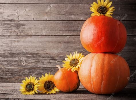 Premium Photo Pumpkins And Sunflowers On Wooden Background