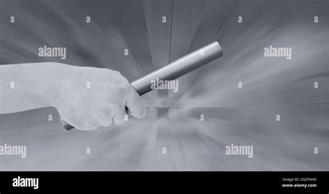 Black And White Image Of Close Up Of Hand Holding A Baton Against Grey