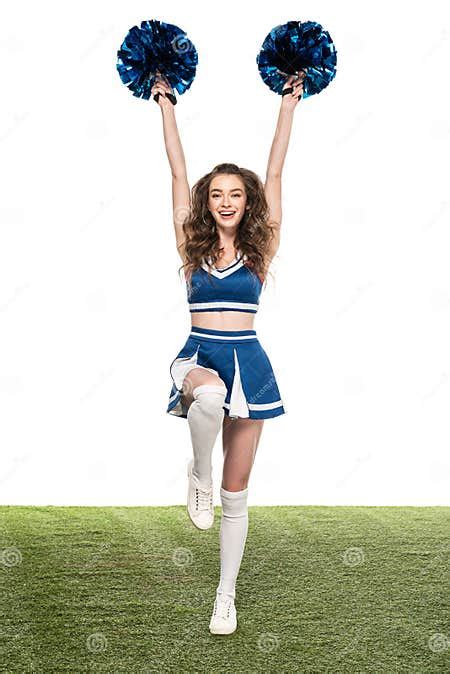 Happy Cheerleader Girl In Blue Uniform Dancing With Pompoms On Green Field Isolated On White