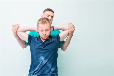 male patient receiving massage from therapist a chiropractor stretching his patient`s spine and