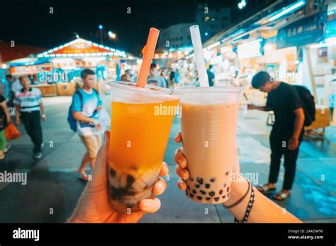 tourists hands holding taiwanese bubble tea at dongdamen night market hualien taiwan stock