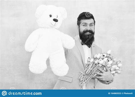 surprise pour elle un homme barbu en costume de monsieur tient l ours en peluche et le bouquet