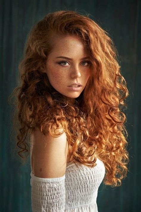 A Woman With Long Red Hair Is Posing For The Camera