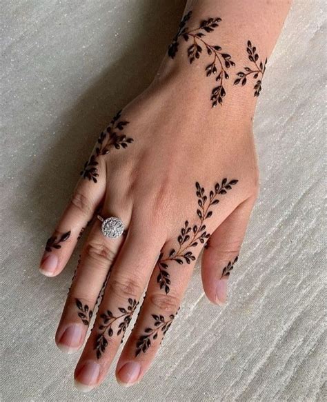A Womans Hand With Black Henna Tattoos On Her Left Wrist And Fingers