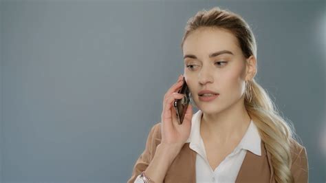 Serious Business Woman Talking Mobile Phone On Gray Background