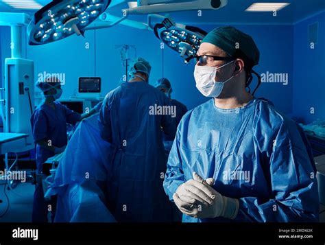 Surgery Professional Surgeon In Blue Scrub And Protective Mask