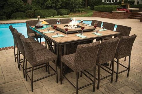 An Outdoor Dining Table With Six Chairs And A Fire Pit In The Middle Of It