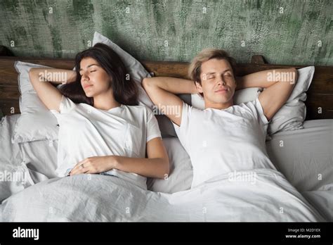 Young Couple Resting Sleeping Well Together In Comfortable Bed Stock