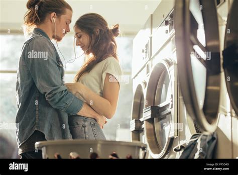 Couple Standing Facing Each Other In A Laundry Room With Closed Eyes