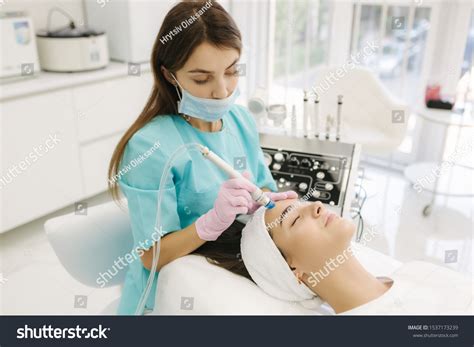 Professional Female Cosmetologist Doing Hydrafacial Procedure Stock