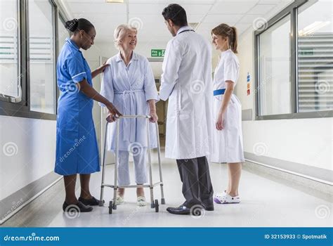 Senior Female Hospital Patient In Walking Frame Doctor Nurse Stock