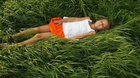 Little Girls Resting On The Green Grass Beautiful Kids Lying On The