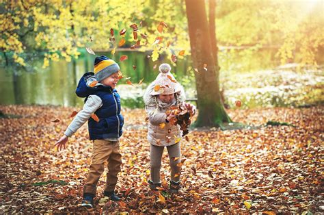 Two Children Playing With Leaves In Forest Stock Photo 171115