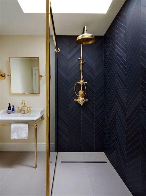 15 black herringbone tiles and a brass fixture make the shower space really stand out and look